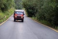 Orange Land Rover Defender. Front side of offroad vehicle. 4x4 tour.