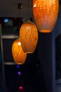 Orange lanterns in the form of a straw chandelier in a dim room