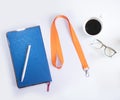 Orange Lanyard Neck Strap, Blue notebook paper, Metal silver pen on white desk