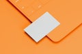 Orange laptop with white blank business card on orange background. 3d rendering. Cozy working place. Minimalism