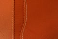 Orange leather with white stitch closeup for background.