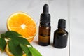 Orange, leaves and brown bottles with essential oil on wooden table Royalty Free Stock Photo