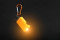 Orange led Flashlight with a carabiner on a black background. LED lights in flight Royalty Free Stock Photo