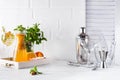 Orange lemonade in the decanter on a wooden tray and Cocktail shaker for preparing a summer cocktail with a place for