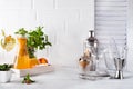 Orange lemonade in the decanter on a wooden tray and Cocktail shaker for preparing a summer cocktail with a place for