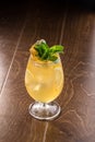 Orange Lemonade with ice cubes and mint leaves in tall glass on wooden table Royalty Free Stock Photo