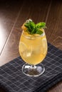 Orange Lemonade with ice cubes and mint leaves in tall glass on wooden table Royalty Free Stock Photo