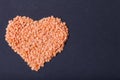 Orange lentils in a heart shape on a black background Royalty Free Stock Photo