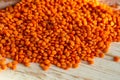 Orange lentils on a white wooden background.