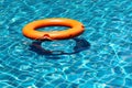 Orange life buoy floating on the surface of blue water Royalty Free Stock Photo