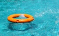 Orange life buoy floating on the surface of blue water Royalty Free Stock Photo