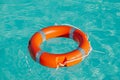 Orange life buoy floating on water in a pool, safety equipment Royalty Free Stock Photo