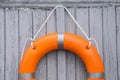 Orange life buoy hanging on light wooden wall Royalty Free Stock Photo