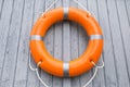 Orange life buoy hanging on light wooden wall Royalty Free Stock Photo