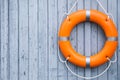 Orange life buoy hanging on light wooden wall, space for text Royalty Free Stock Photo