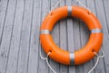 Orange life buoy hanging on light wooden wall, space for text Royalty Free Stock Photo