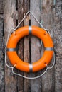 Orange life buoy hanging on wooden wall Royalty Free Stock Photo