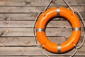 Orange life buoy hanging on wooden wall, space for text Royalty Free Stock Photo