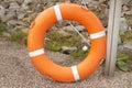 An orange life buoy hangs on the beach. Mockup with space for text, rescue work Royalty Free Stock Photo