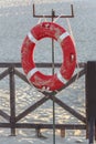 Orange life buoy with rope on a wooden pier near the sea. Close-up of a lifebuoy on the dock Royalty Free Stock Photo