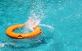 Orange life buoy is splashing with clear blue water in swimming Royalty Free Stock Photo