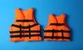 Orange life jackets on blue background. Personal flotation device Royalty Free Stock Photo