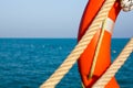 Orange life preserver and two Maritime rope on the background of blue sea and sky. Close up. Lifebuoy on the background of the sea Royalty Free Stock Photo