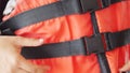 Orange life safety jacket and hand wearing it