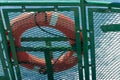 Orange life saving ring hanging on edge of a ship railing Royalty Free Stock Photo