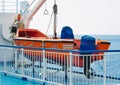 Orange lifeboat on deck of a sea vessel
