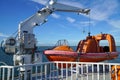 Orange lifeboat, rescue boat of ferry boat sailing on the sea with blue sky and coastline. Royalty Free Stock Photo