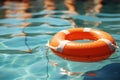Orange lifebuoy on blue water in swimming pool closeup