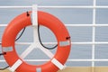 Orange lifebuoy emergency gear/ device/ equipment with reflective silver strips on cruise ship deck.