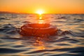 Orange lifebuoy floating in open sea. Safety, rescue and emergency lifesaving concept