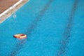 Orange lifebuoy floating on a pool