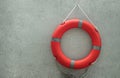 Orange lifebuoy with grey strips Rescue ring buoy .hanging on small gravel wall near swimming pool Royalty Free Stock Photo