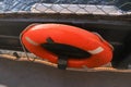 Orange lifebuoy hanging on a boat, sea view.