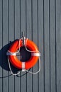 An Orange Lifebuoy hanging on a Grey Wall Royalty Free Stock Photo