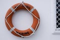 Orange lifebuoy hanging on a wall Royalty Free Stock Photo