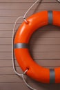 Orange lifebuoy on light brown wooden background. Rescue equipment Royalty Free Stock Photo