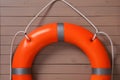 Orange lifebuoy on light brown wooden background. Rescue equipment Royalty Free Stock Photo