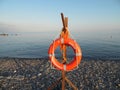 Orange lifebuoy on a pebble beach at the Black Sea