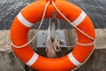 Orange lifebuoy with rope on a pier near the water Royalty Free Stock Photo