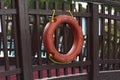 Orange lifebuoy with rope on a wooden pier near sea. Close up of lifebuoy on wooden pier at the beach photo