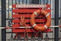 Orange lifebuoy with ropes hanging on a shield with a gaff. Inscription Rescue post Royalty Free Stock Photo