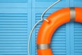 Orange lifebuoy on turquoise wooden background, space for text. Rescue equipment Royalty Free Stock Photo