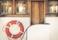 Orange lifebuoy on vintage white boat in port