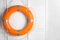 Orange lifebuoy on white wooden background, space for text. Rescue equipment Royalty Free Stock Photo