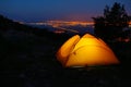 Orange lighted inside tent on mountain above city in night lights Royalty Free Stock Photo