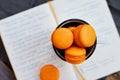 Orange macaroon upon open diary with notes